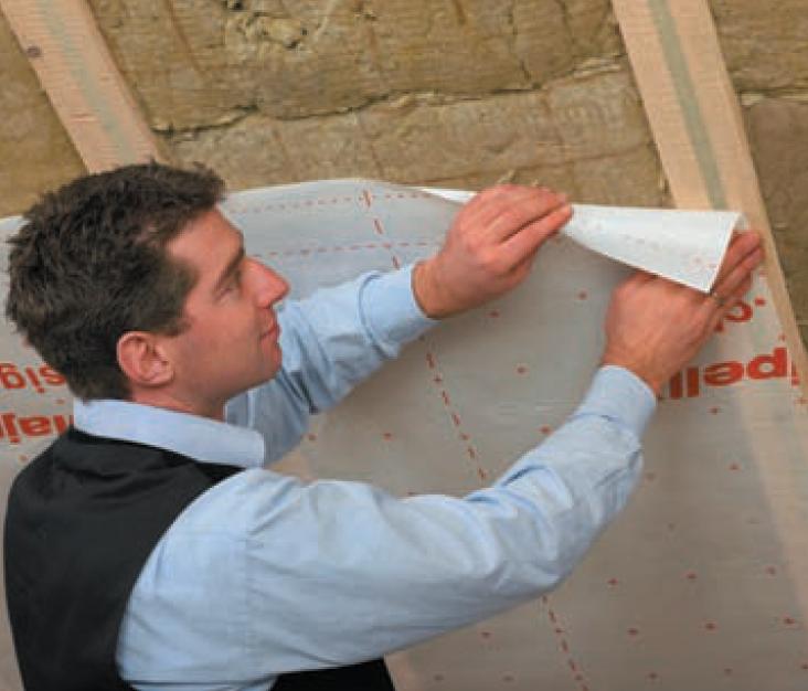 La mise en oeuvre d’un adhésif double face sur les montants permet de positionner la membrane d’étanchéité à l’air, avant de la jointoyer entre chaque lé La mise en oeuvre d’un adhésif double face sur les montants permet de positionner la membrane d’étanchéité à l’air, avant de la jointoyer entre chaque lé